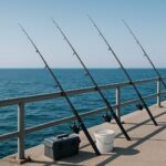 青空のもと堤防に並べられた釣り竿とタックルボックス