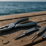 堤防の上に置かれたフィッシングプライヤーと釣り道具の静物写真