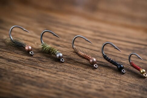 木の台に並べられた精巧な釣り針のクローズアップ